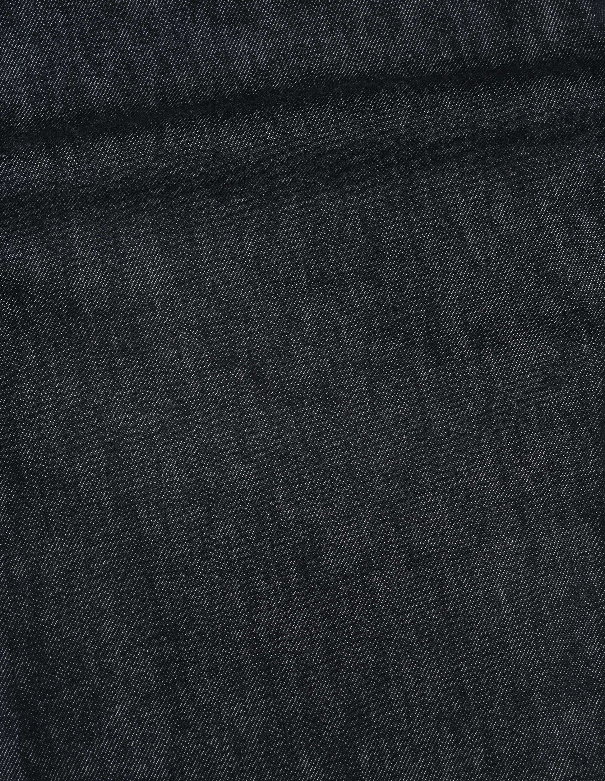 Close-up of Visual Clothing's overdyed black denim fabric.